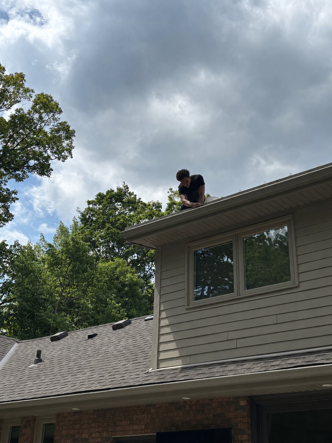 Crew cleaning eavestrough on a Guelph roof